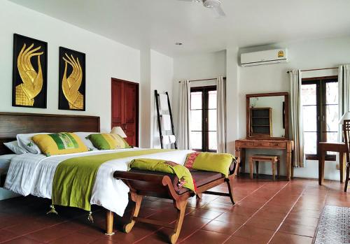 a bedroom with a large bed and a mirror at Jasmine Hills Lodge in Doi Saket