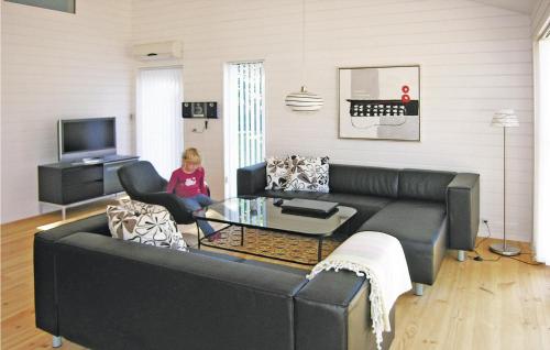 a little girl sitting on a couch in a living room at Holiday Home Sahara Rønne I in Hasle