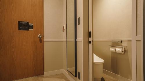 a bathroom with a toilet and a glass door at Hotel Aoka Kamigoto in Shinkamigoto
