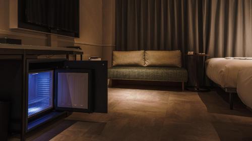 a room with a bed and a tv and a chair at Hotel Aoka Kamigoto in Shinkamigoto
