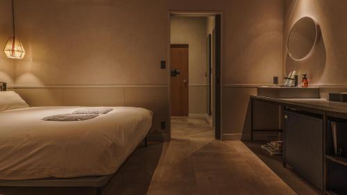 a bedroom with a bed and a bathroom with a sink at Hotel Aoka Kamigoto in Shinkamigoto