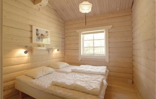 a bedroom with two beds in a wooden room at Holiday Home Frederiksvej Nexø Denm in Balke