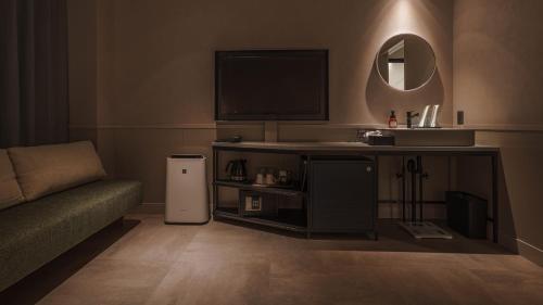 a living room with a couch and a television at Hotel Aoka Kamigoto in Shinkamigoto