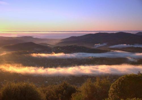 a view of a foggy valley with trees and mountains at Domaine du Bois d'Amont in Cabris