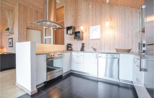 ØrbyにあるStunning Home In Knebel With Kitchenの白い家電製品と木製の壁が備わるキッチン