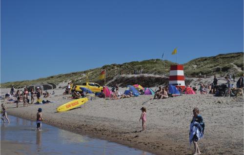 a group of people on a beach with a lighthouse at Lovely Home In Ringkøbing With Wifi in Søndervig