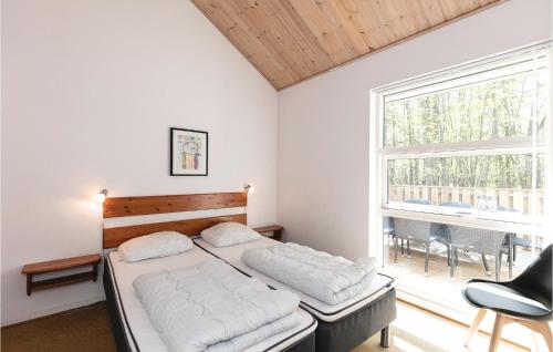 - une chambre avec un lit et une grande fenêtre dans l'établissement Rubinsen Skovhuse, à Hasle