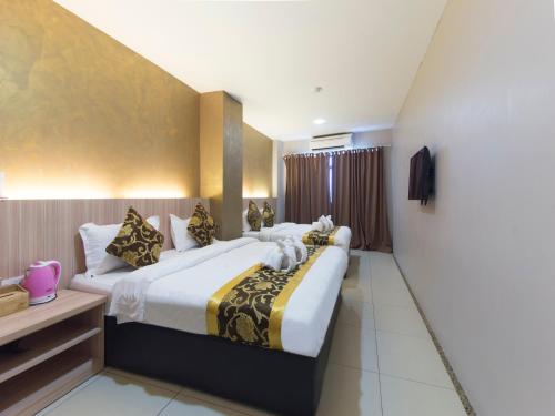 a hotel room with two beds and a window at Top Garden Hotel in Hutan Melintang