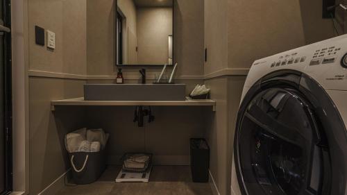 a laundry room with a sink and a washing machine at Hotel Aoka Kamigoto in Shinkamigoto