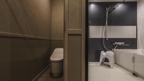 a small bathroom with a toilet and a shower at Hotel Aoka Kamigoto in Shinkamigoto