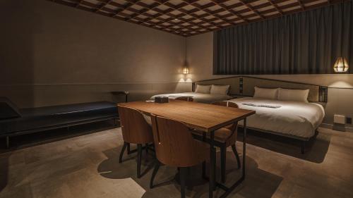 a hotel room with a bed and a table and chairs at Hotel Aoka Kamigoto in Shinkamigoto