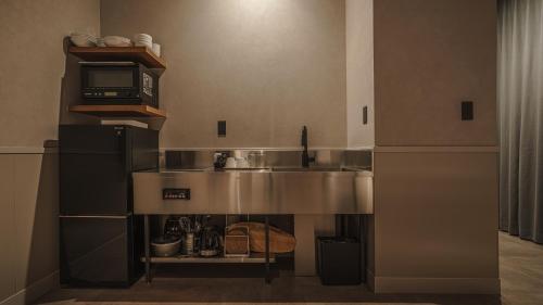 a kitchen with a sink and a microwave at Hotel Aoka Kamigoto in Shinkamigoto