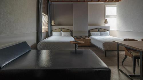 a hotel room with two beds and a couch at Hotel Aoka Kamigoto in Shinkamigoto