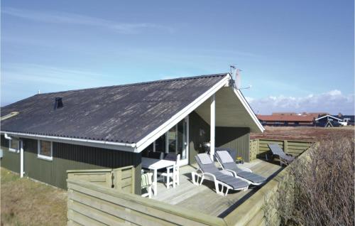 a house with a deck with chairs and a table at Holiday Home Arvidvej I Dnmk in Bjerregård