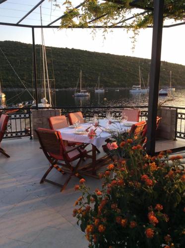 een tafel en stoelen op een patio met uitzicht op het water bij Apartment Bigovo in Tivat