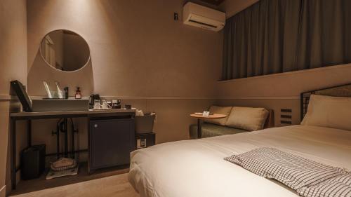 a bedroom with a bed and a sink and a mirror at Hotel Aoka Kamigoto in Shinkamigoto