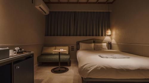 a hotel room with a bed and a chair at Hotel Aoka Kamigoto in Shinkamigoto