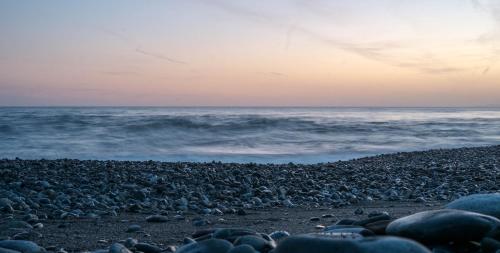 a group of rocks on the beach at sunset at Sui Tetti, Caressa de mä in Bordighera