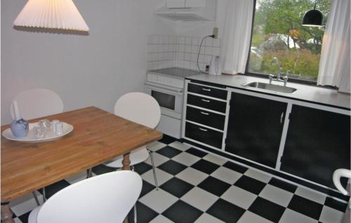 eine Küche mit einem Tisch, Stühlen und einem Waschbecken in der Unterkunft Awesome Home In Rnne With Wifi in Rønne