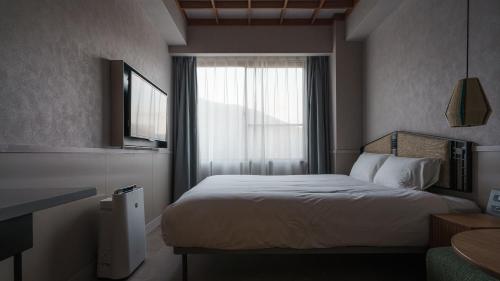 a hotel room with a bed and a window at Hotel Aoka Kamigoto in Shinkamigoto