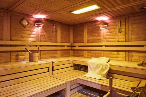 a sauna with wooden walls and benches and a sink at Camping Dreiländereck Blockhütten & Apartments in Ried im Oberinntal