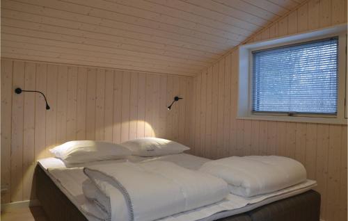 a bedroom with a bed with white sheets and a window at Awesome Home In Jgerspris With 3 Bedrooms, Sauna And Wifi in Jægerspris