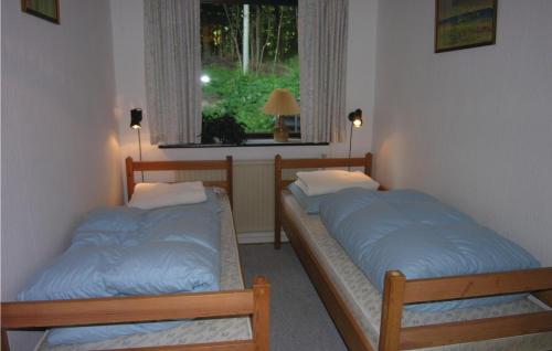 two beds in a room with a window at Awesome Home In Rnne With Wifi in Rønne
