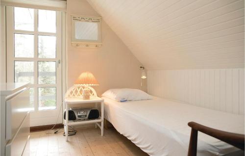sypialnia z łóżkiem i lampką na stole w obiekcie Cozy Home In Pandrup With Wifi w mieście Rødhus
