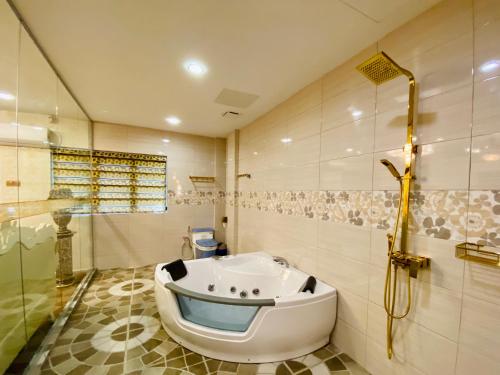 a bathroom with a bath tub and a shower at J Boutique Hotel 新张优惠 in Muar