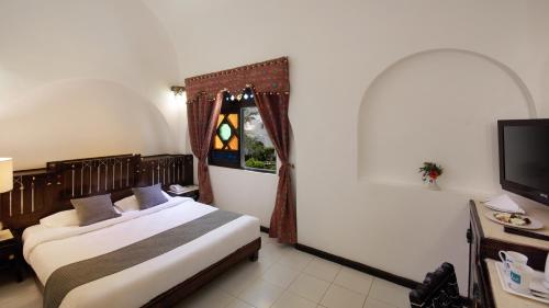 a hotel room with a bed and a television at Arabella Azur Resort in Hurghada