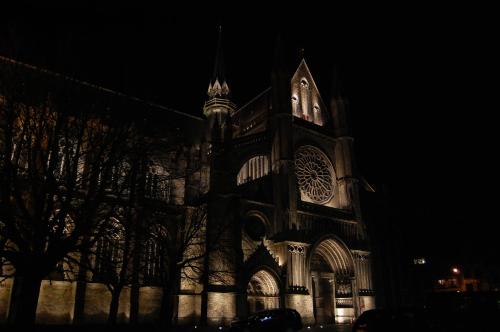 a large building with a clock tower at night at Het Houten Paard in Ypres