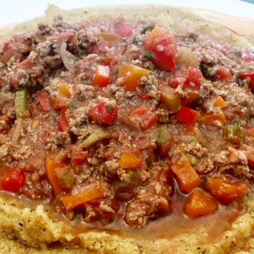 a pizza with meat and vegetables on a plate at CAMINATA 415 in Fiorenzuola dʼArda