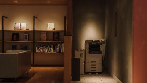 a room with a desk and a shelf with books at Hotel Aoka Kamigoto in Shinkamigoto