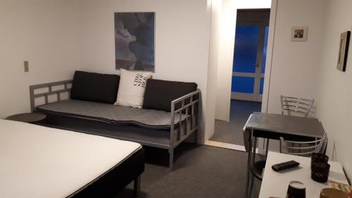 Cette chambre comprend un canapé, un lit et une table. dans l'établissement Landsted med aktivitethal, à Karby