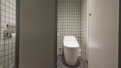 a bathroom with a toilet in a tiled room at Hotel Aoka Kamigoto in Shinkamigoto