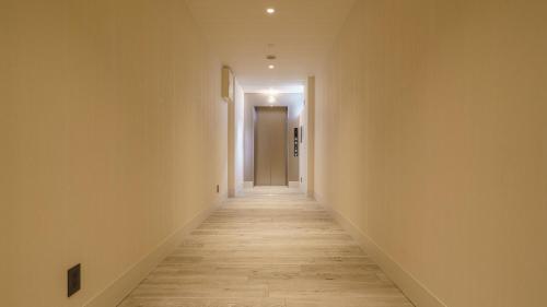a hallway with white walls and wooden floors at Hotel Aoka Kamigoto in Shinkamigoto