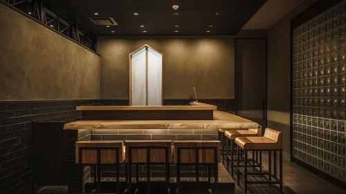 a bar in a wine cellar with two stools at Hotel Aoka Kamigoto in Shinkamigoto