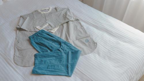 a shirt and a bag on a bed at Hotel Aoka Kamigoto in Shinkamigoto