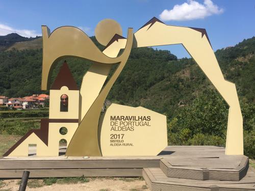 a statue of a monument with a mountain in the background at Casa da Fichua in Sistelo