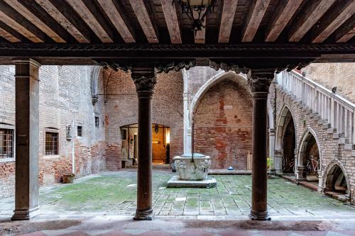 an old building with a fountain in a courtyard at PALAZZO BERNARDO SAN POLO APARTMENT 100 MQ in Venice