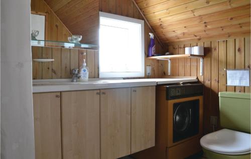 a small kitchen with a washing machine and a window at Beautiful Home In Fan With Sauna in Fanø
