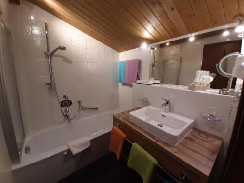 a bathroom with a tub and a sink and a mirror at Forellenstube in Lofer