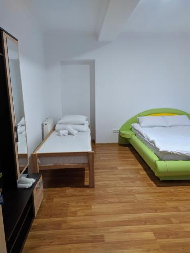 a room with two beds and a table and a television at Mirage in Chernivtsi