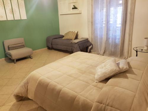 een slaapkamer met een groot bed en een stoel bij Ai Carrettieri della Cattedrale in Palermo