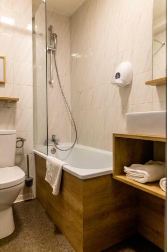 a bathroom with a shower and a tub and a toilet at Ostal Pau Universite - Sure Hotel Collection by Best Western in Pau
