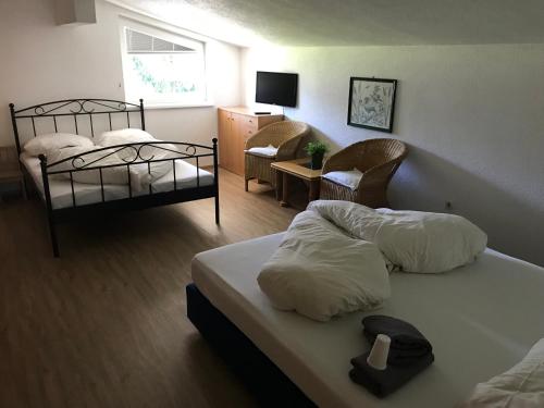 a hotel room with two beds and a living room at Naturparkhotel Florence in Weissenbach am Lech