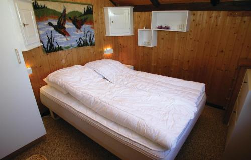 a bed in a room with a wooden wall at 2 Bedroom Lovely Home In Rm in Bolilmark