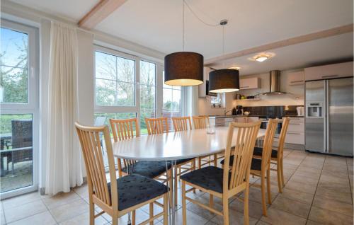 a kitchen and dining room with a table and chairs at Holiday Home Romo With Sea View 154 in Bolilmark
