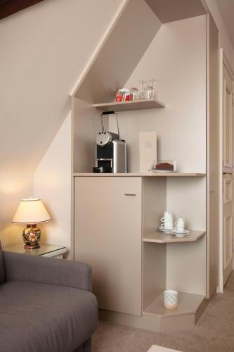 a living room with a couch and a shelf under the stairs at Relais & Châteaux La Maison Des Têtes in Colmar