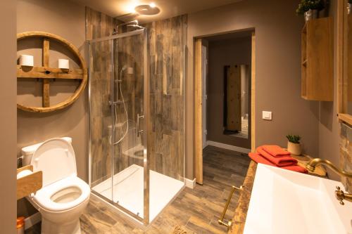 a bathroom with a toilet and a glass shower at J&J Room - Hébergement d'exception prés de Provins! in Le Bas Courton
